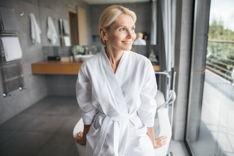 Happy senior woman after showering in high-spec walk-in bathroom in Portsmouth, featuring modern easy-access design.